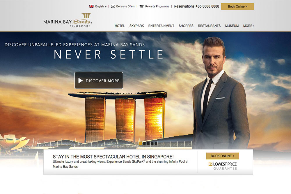 David Beckham in a suit standing in front of a luxury resort